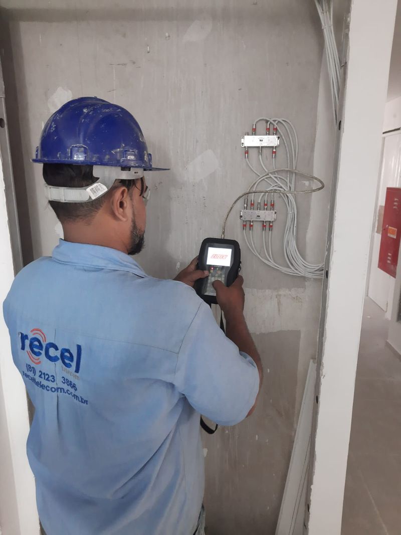 Técnico medindo sinal no quadro de distribuição