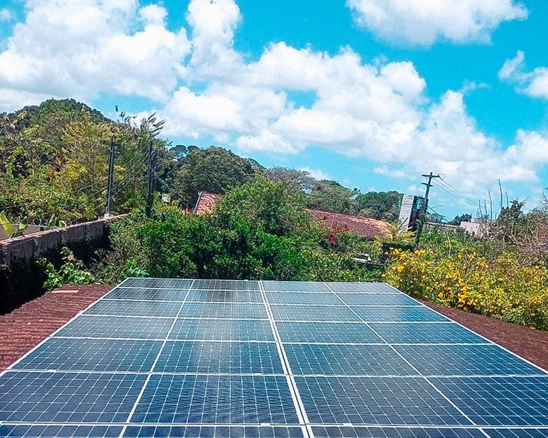 Usina solar residencial cercada de jardim